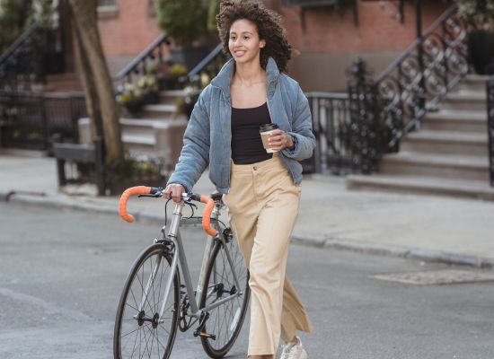 woman walking her bike across the street