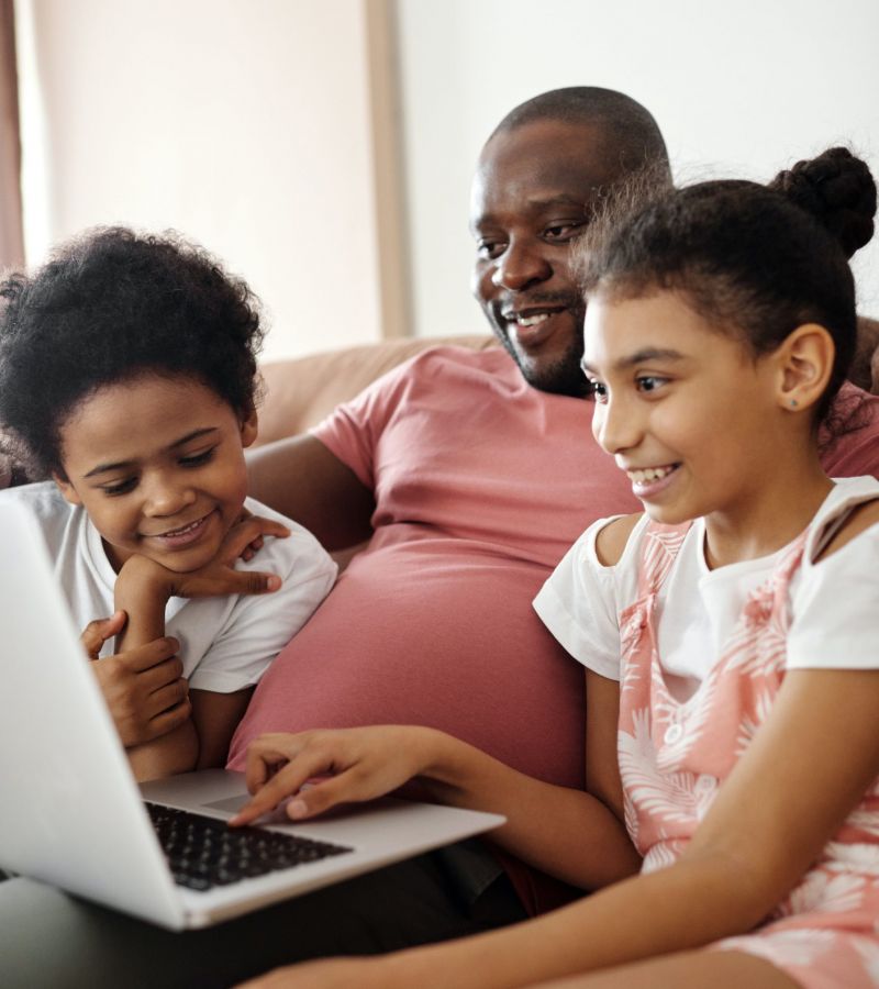 dad looking at laptop with his two children