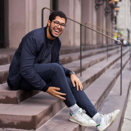 smiling man sitting on steps outside